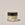 Acure Scar Treatment Balm jar on a beige background